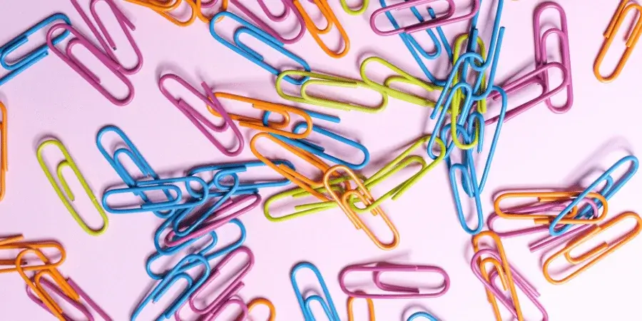 Assorted colorful paper clips stacked together, totaling 7 inches.