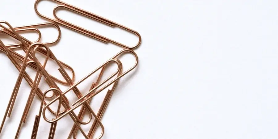 Three black spoons placed neatly on a beige surface.