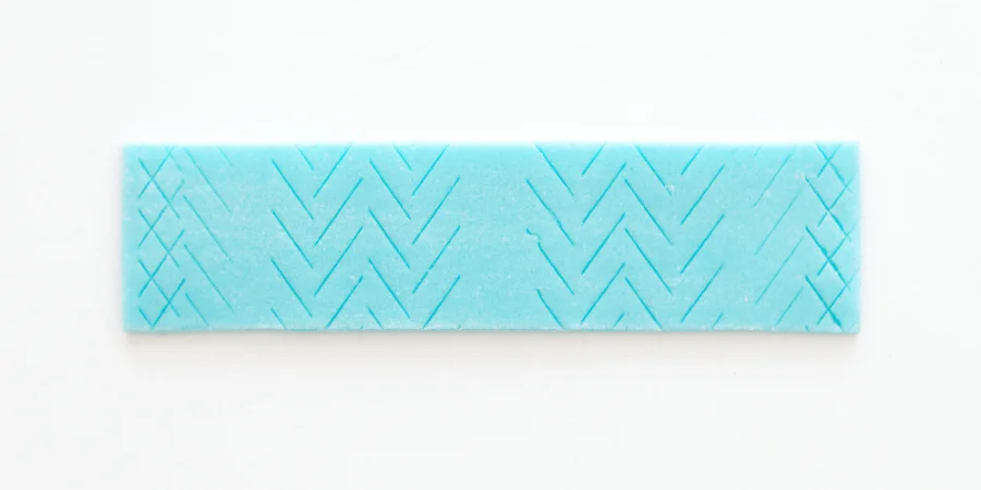 Piece of blue chewing gum weighing 1 gram, placed on a white background.