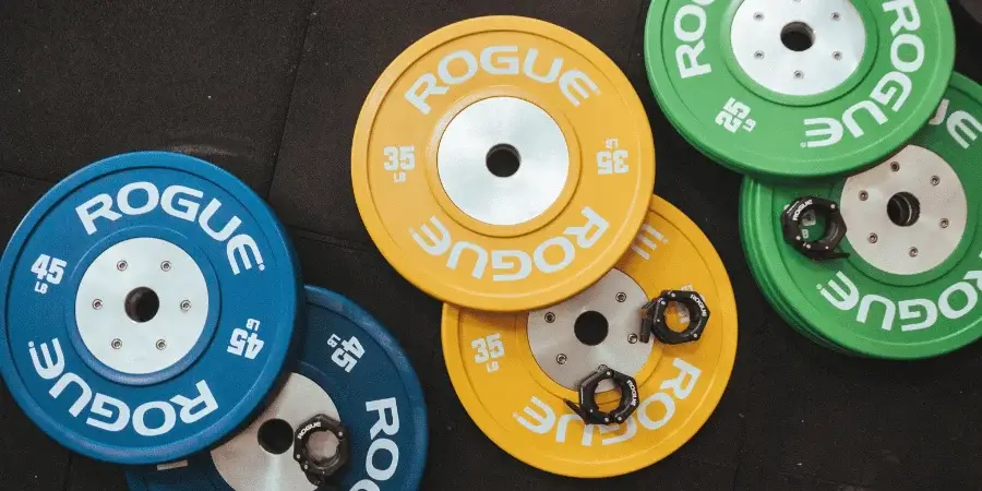 Colorful weight plates in a gym, including a 20 kg plate.