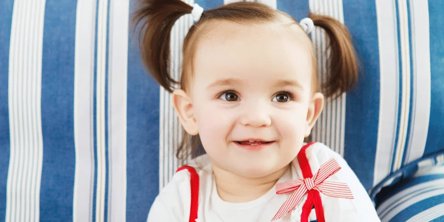 Smiling child sitting on a couch.
