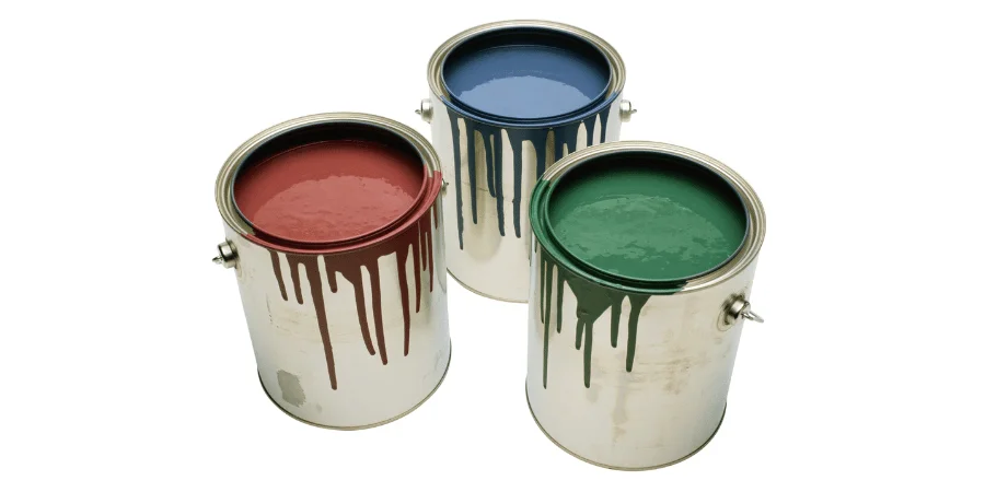 Three open cans of paint in red, blue, and green, with some paint dripping over the edges.