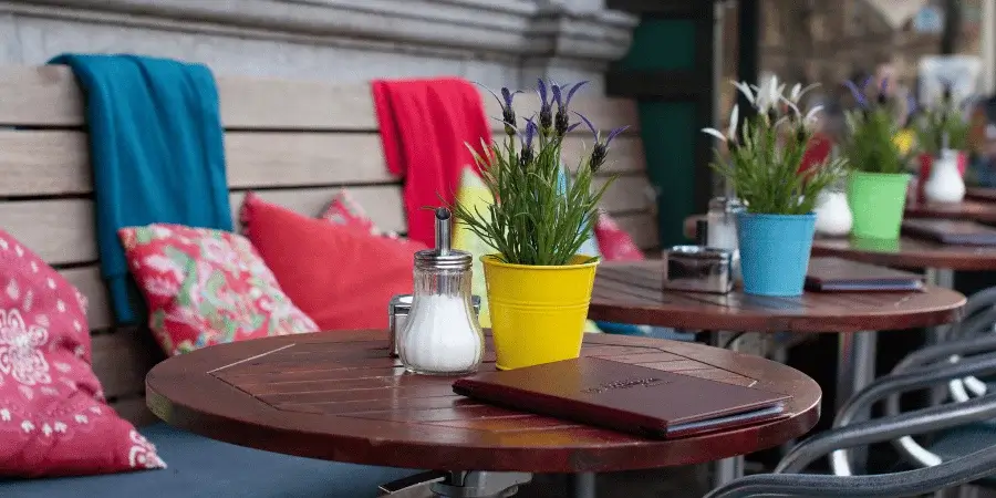 A colorful outdoor seating area with a table and plants, perfect for relaxing.
