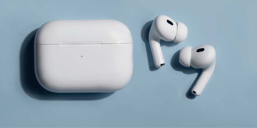 White wireless earpods and charging case placed on a smooth light blue background.