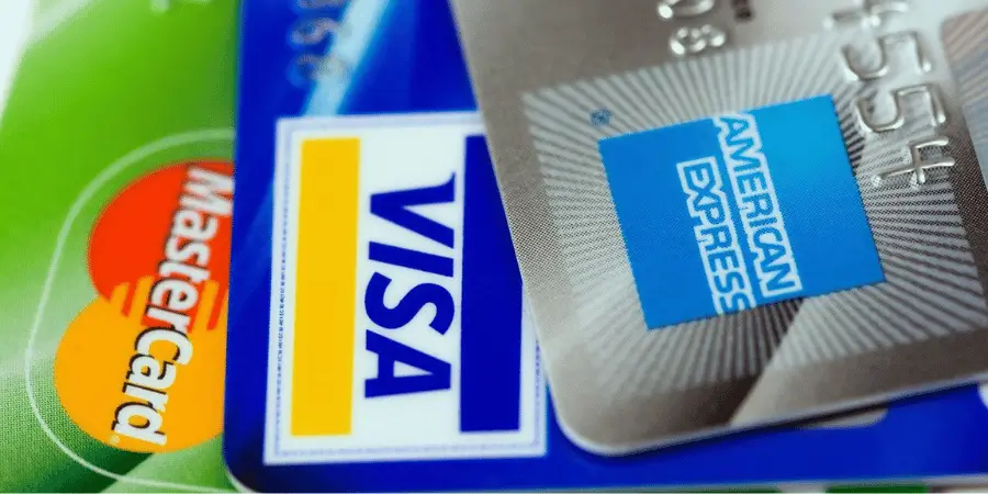 A close-up view of a Visa, MasterCard, and American Express credit cards stacked together.