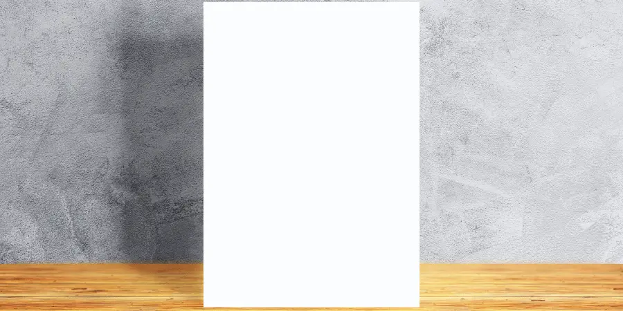 A clean, blank white paper displayed on a wooden table with a gray textured wall in the background.