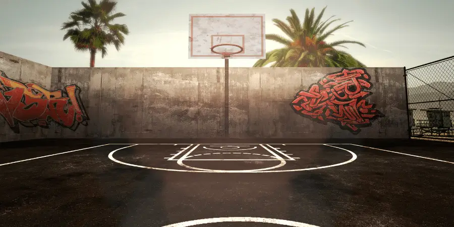 Outdoor basketball court with graffiti art on the walls, perfect for casual play and sports enthusiasts.