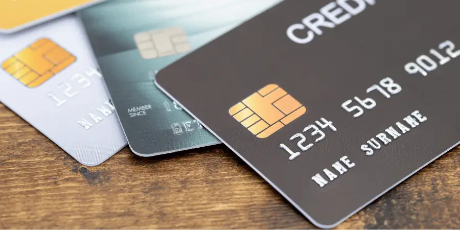 Stack of modern debit and credit cards with smart chip on wooden table for secure banking transactions