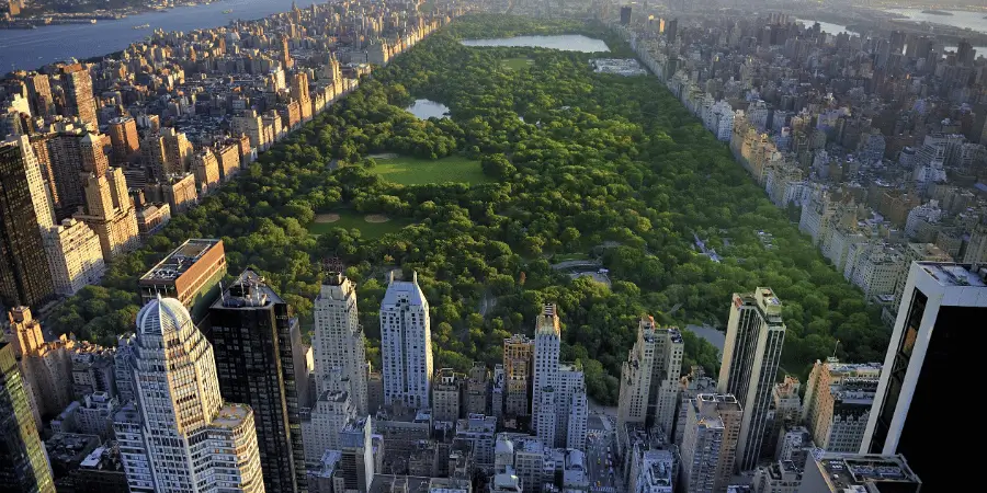 Aerial view of Manhattan revealing Central Park's vast green expanse framed by surrounding skyscrapers and city skyline.