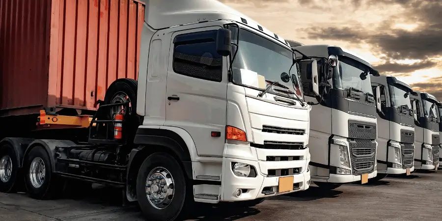A fleet of white trucks lined up in a storage yard ready for transportation and logistics.