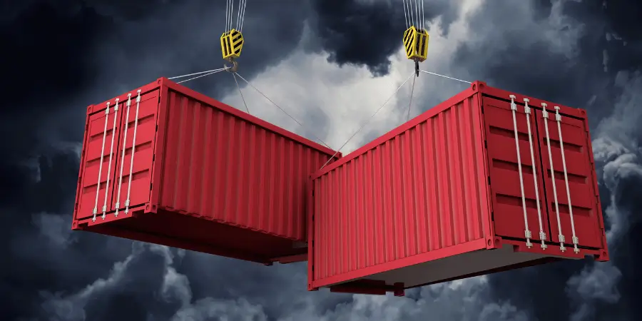 Red shipping containers suspended by cranes under stormy skies, symbolizing global trade and transport.