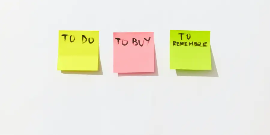 Three colorful sticky notes with handwritten tasks: "To Do", "To Buy", and "To Remember".