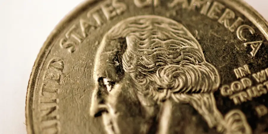 Close-up of a U.S. quarter showing George Washington's face, emphasizing the intricate details of the coin.