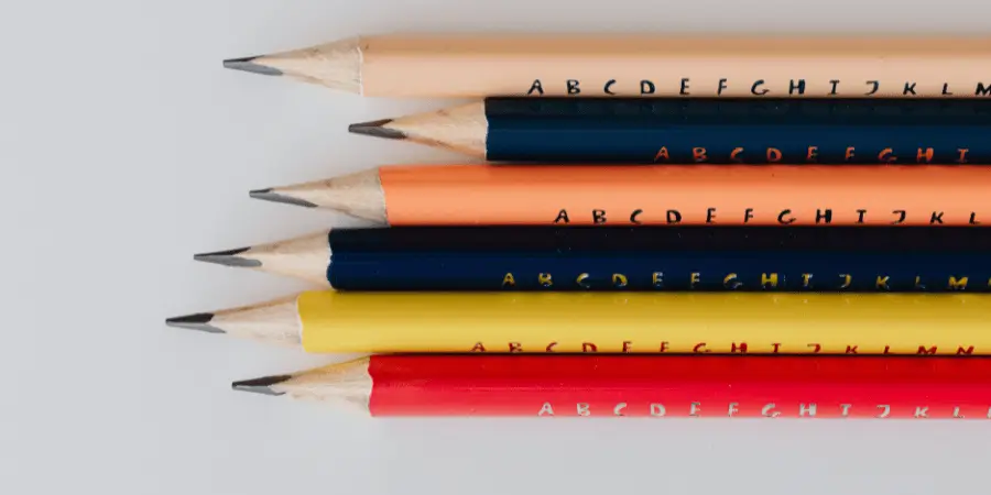 Five sharpened pencils of various colors arranged neatly in a row.